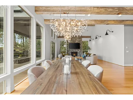 a living room with furniture floor to ceiling window and wooden floor