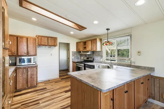 a kitchen with stainless steel appliances granite countertop a sink refrigerator and cabinets
