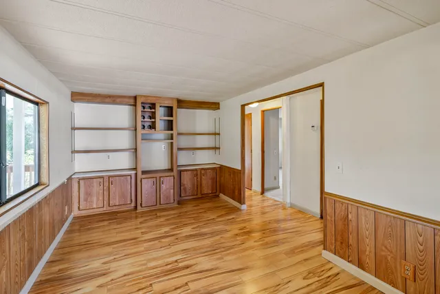a view of empty room with wooden floor and windows