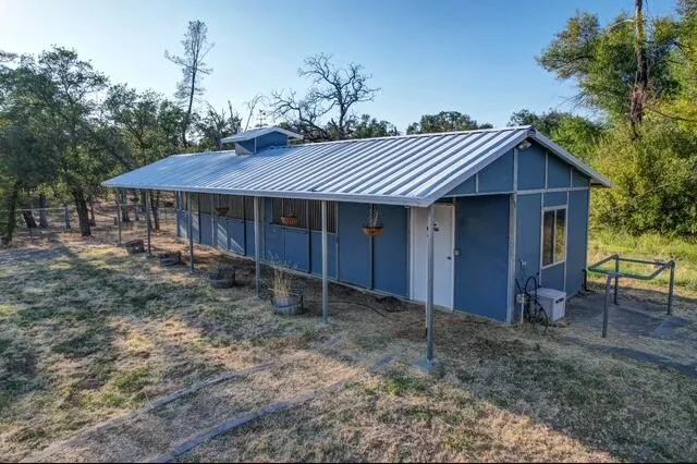 a view of a house with a yard and trees