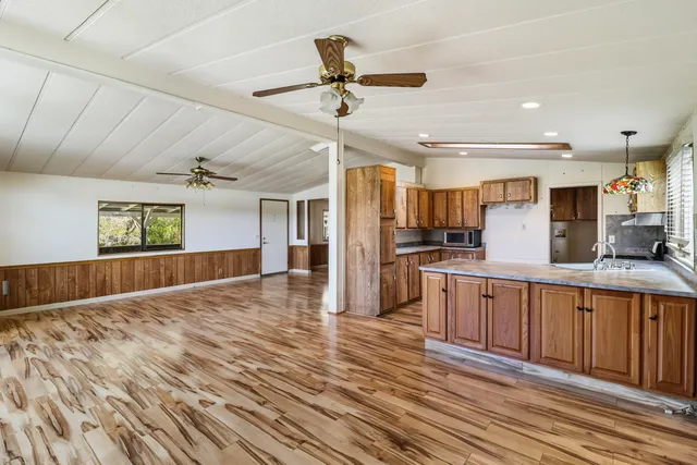 a kitchen with stainless steel appliances kitchen island granite countertop a refrigerator and a sink