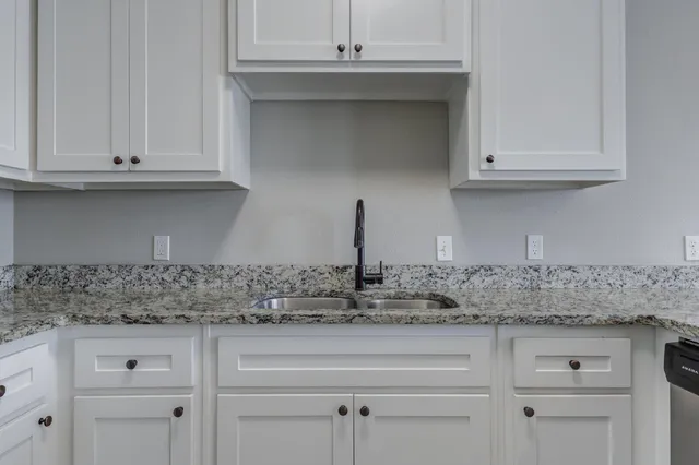 a kitchen with white cabinets and a sink