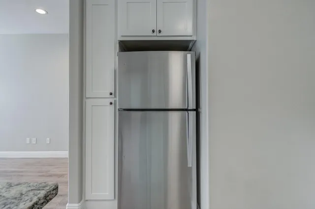 a kitchen with a refrigerator and cabinets