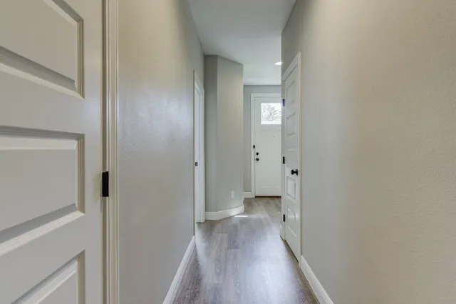 a view of a hallway with wooden floor