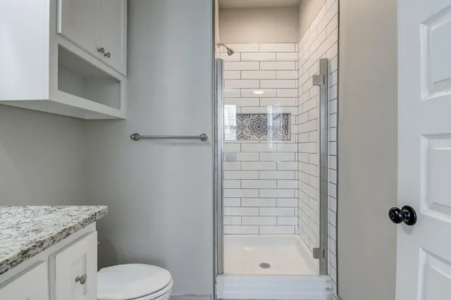 a bathroom with a shower toilet and sink