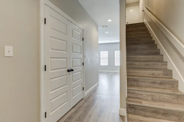 a view of a hallway with wooden floor and entryway