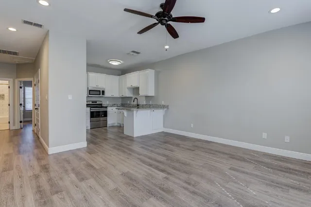 a view of a kitchen with a sink and dishwasher a refrigerator with wooden floor