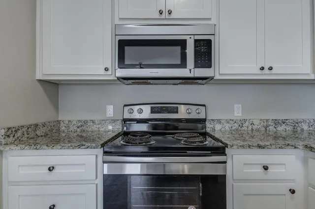 a stove top oven sitting inside of a kitchen
