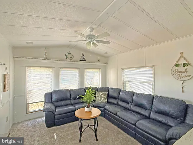 a living room with furniture a ceiling fan and a window