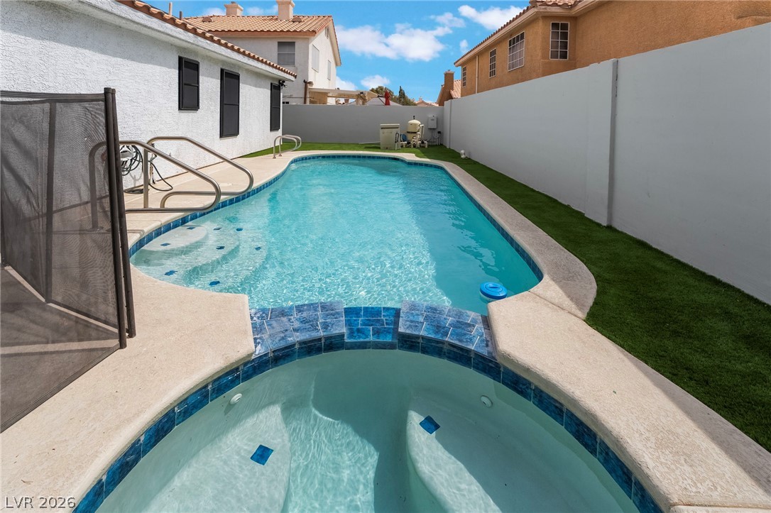 9171 West Viking Road Las Vegas, NV 89147 - Photo 39 of 43 A tranquil backyard oasis features a glistening pool and a relaxing spa, perfect for unwinding.