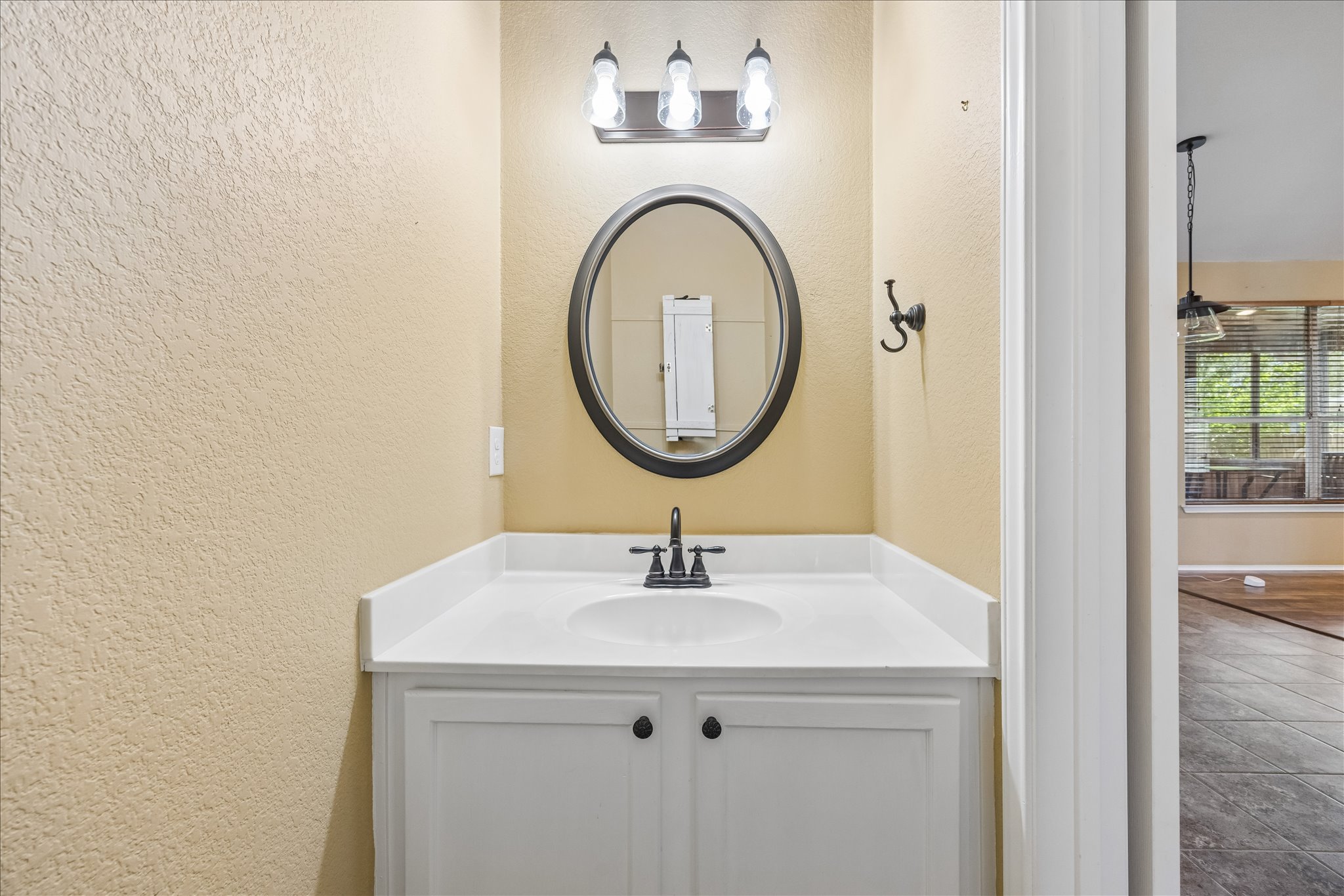338 Spring Branch Loop Kyle, TX 78640 - Photo 26 of 36 A well-lit powder room offers practical elegance with a modern vanity and mirror.