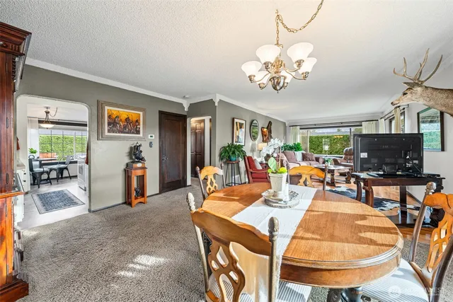a view of a dining room with furniture a chandelier and wooden floor