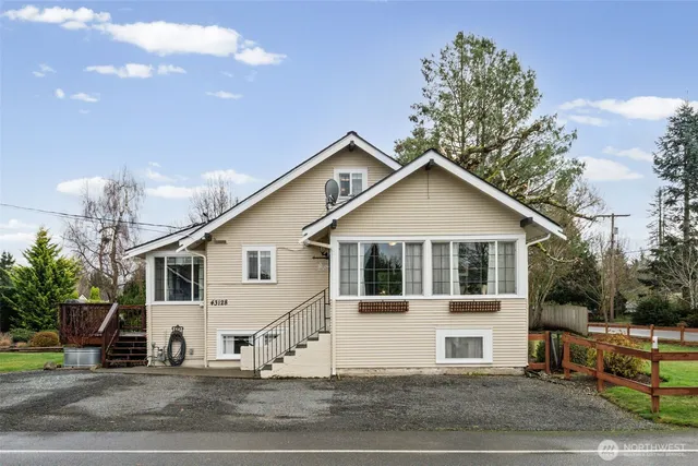 a view of a white house with a yard and plants