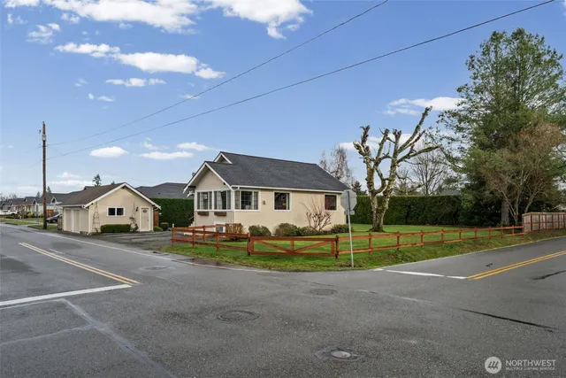 a view of a house with a big yard and large trees