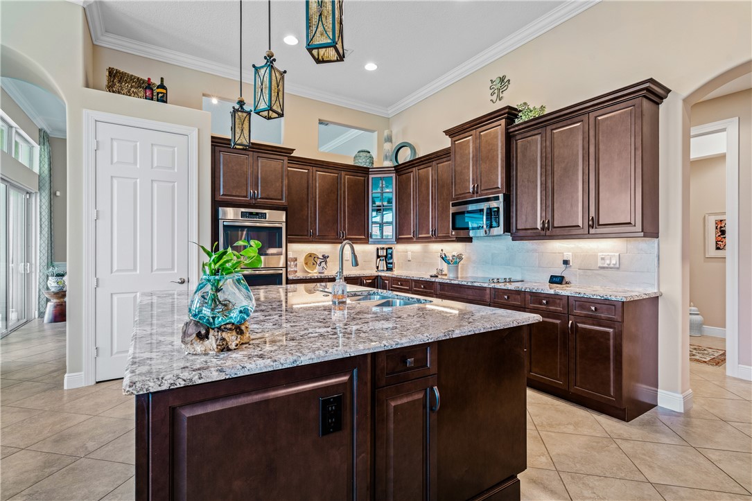 8250 Halbert Lane Vero Beach, FL 32968 - Photo 14 of 36 a kitchen with stainless steel appliances granite countertop a sink a stove a counter space and cabinets