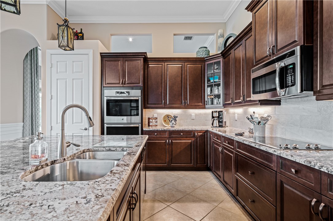 8250 Halbert Lane Vero Beach, FL 32968 - Photo 15 of 36 a kitchen with stainless steel appliances granite countertop a sink dishwasher stove and oven