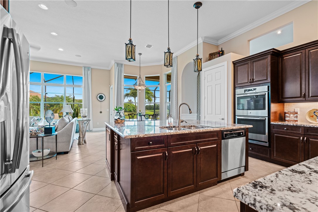 8250 Halbert Lane Vero Beach, FL 32968 - Photo 16 of 36 a kitchen with stainless steel appliances granite countertop a sink a stove and a refrigerator