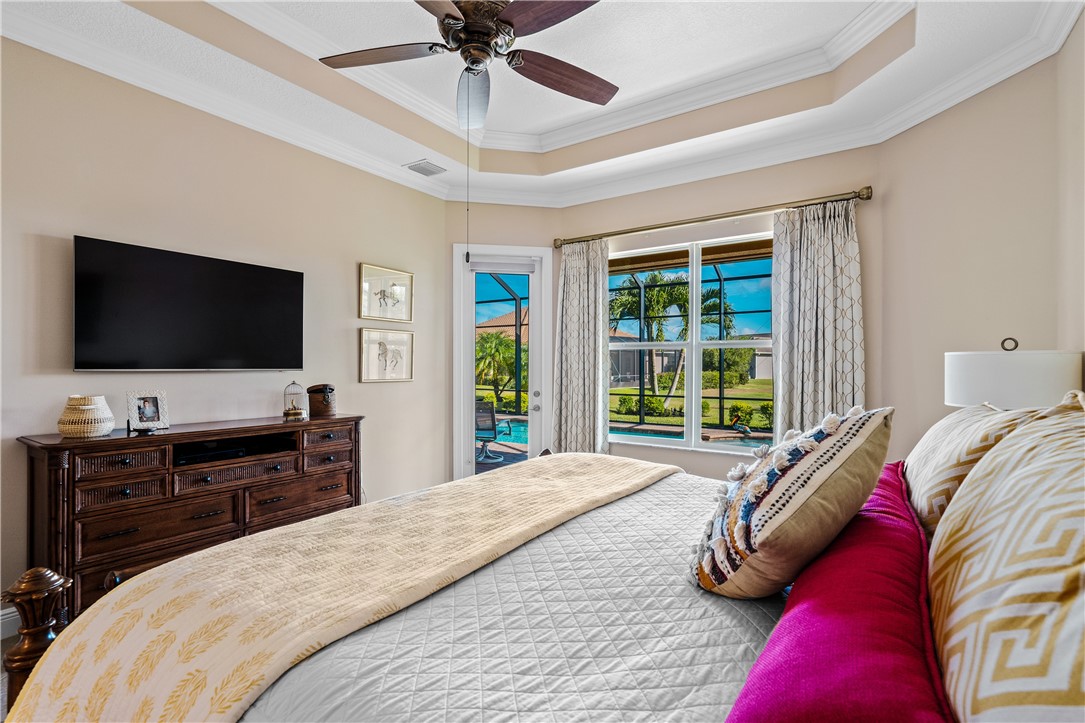 8250 Halbert Lane Vero Beach, FL 32968 - Photo 20 of 36 a bedroom with a bed and a flat tv screen on dresser