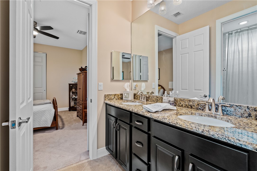 8250 Halbert Lane Vero Beach, FL 32968 - Photo 25 of 36 a en suite bathroom with a granite countertop sink and a mirror