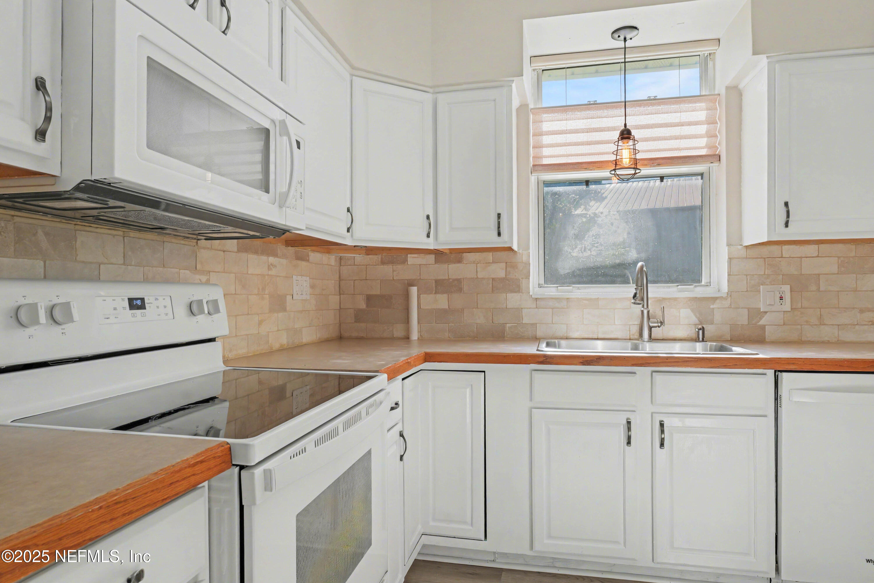 10640 Hemming Road Jacksonville, FL 32225 - Photo 8 of 46 a kitchen with white cabinets and a sink