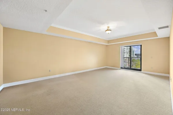 a spacious bedroom with a bed and a window