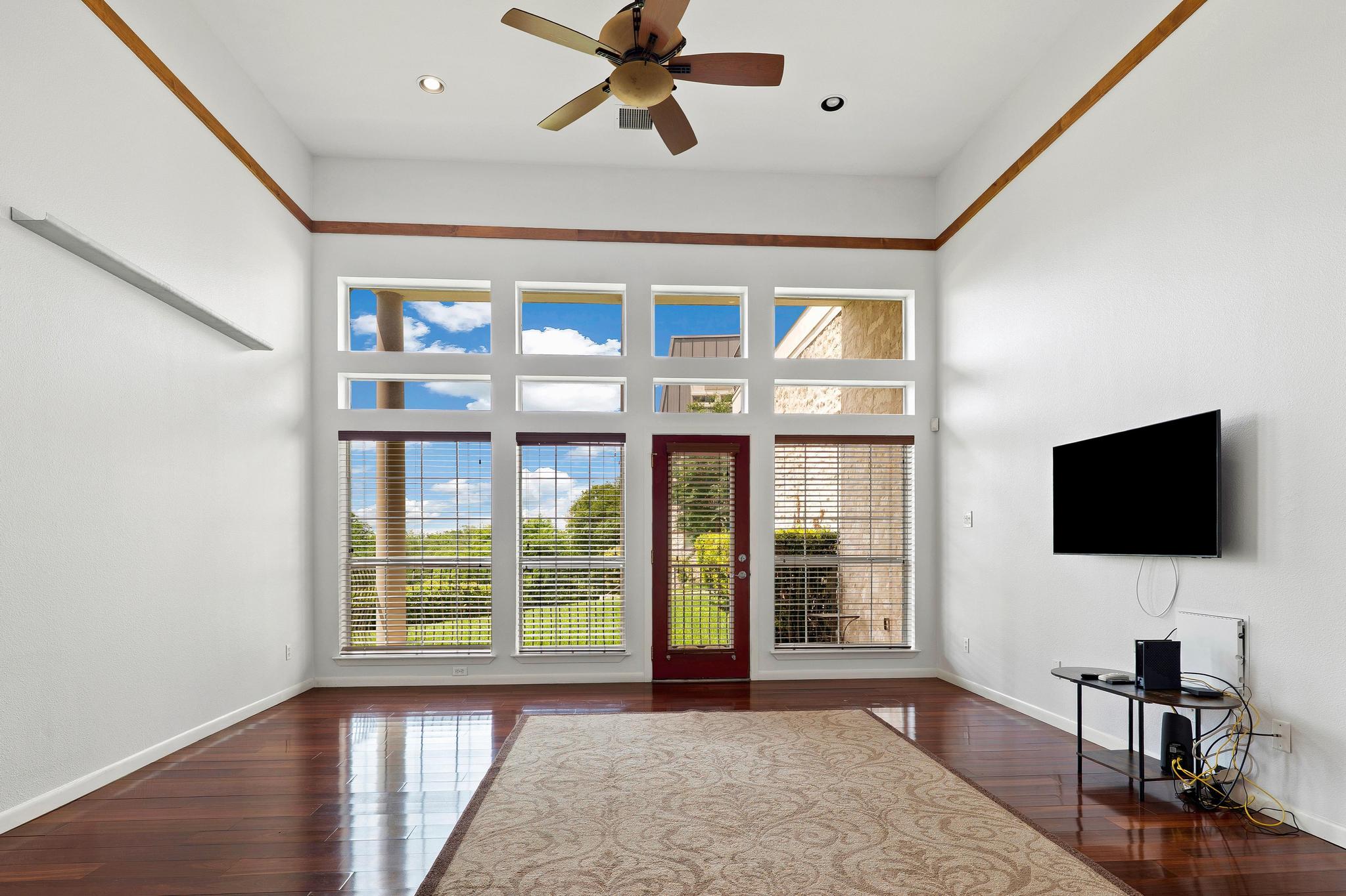 2918 Ranch Road 620, Unit J162 Austin, TX 78734 - Photo 12 of 26 High ceilings featuring a multi-paneled window wall and a ceiling fan