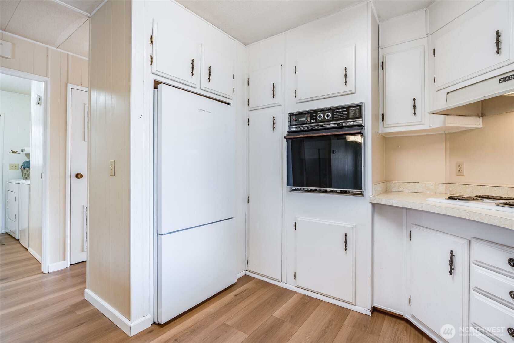 201 Union Avenue Southeast, Unit 111 Renton, WA 98059 - Photo 11 of 40 a kitchen with cabinets stainless steel appliances and wooden floor
