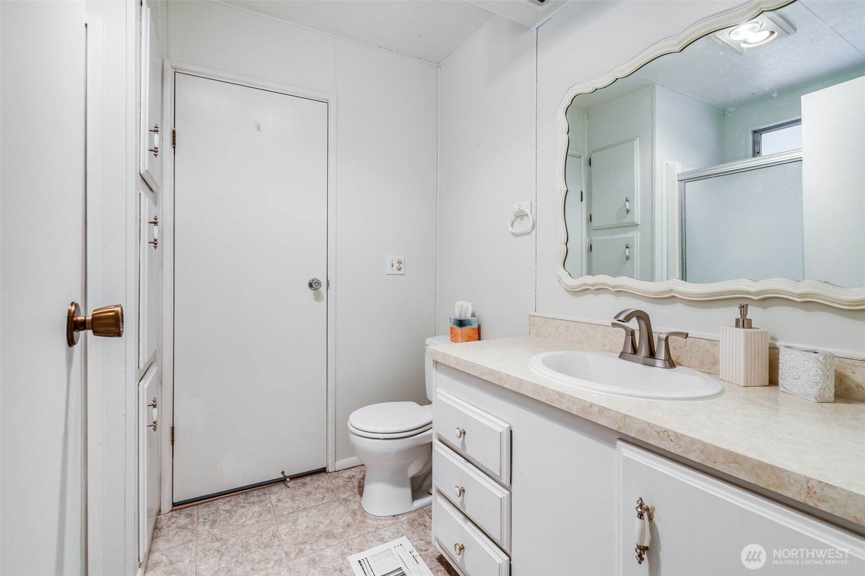201 Union Avenue Southeast, Unit 111 Renton, WA 98059 - Photo 22 of 40 a bathroom with a granite countertop sink a toilet and a mirror
