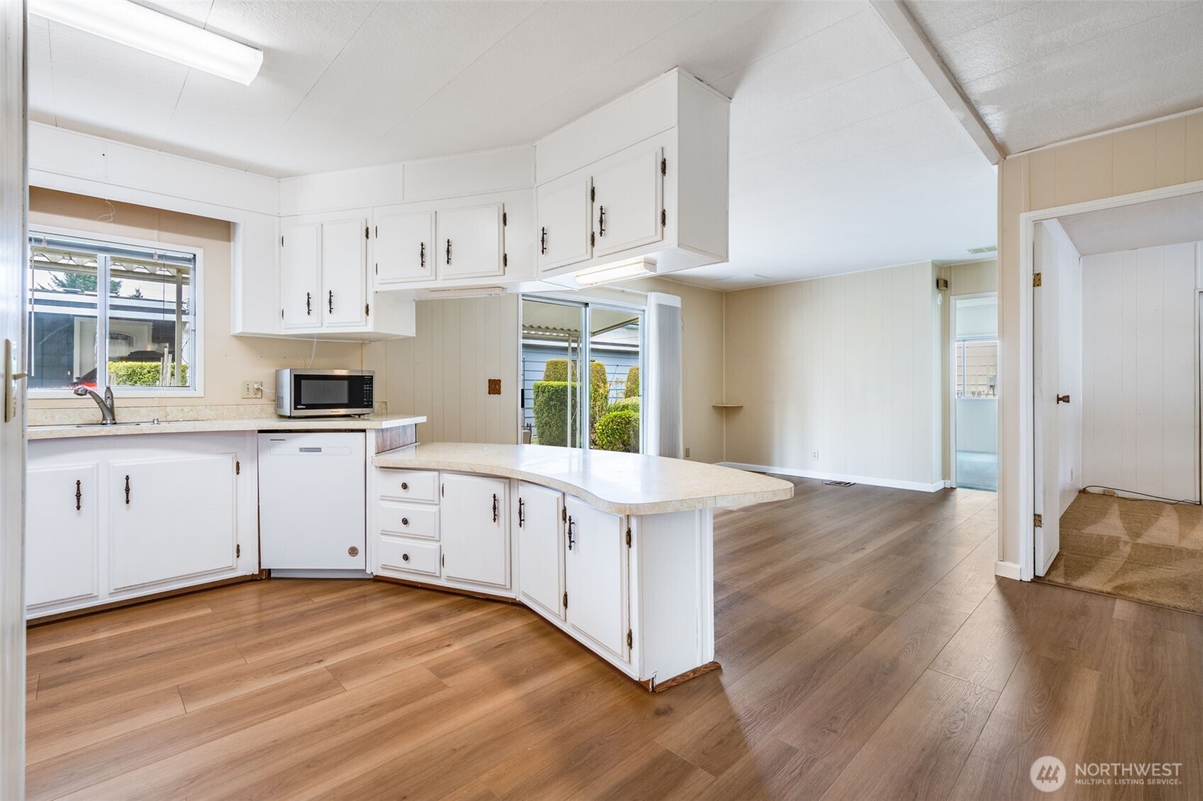 201 Union Avenue Southeast, Unit 111 Renton, WA 98059 - Photo 9 of 40 a kitchen with white cabinets and wooden floors