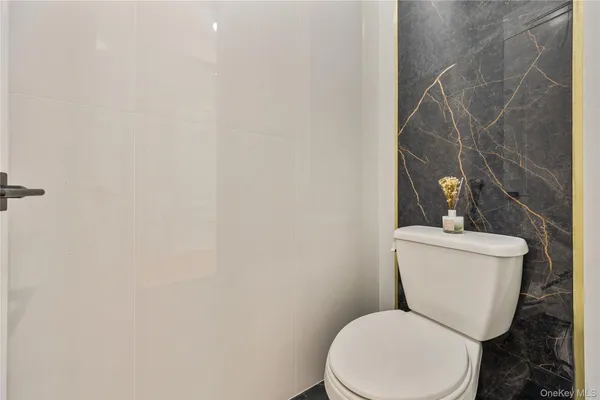 a white toilet sitting next to a white wall