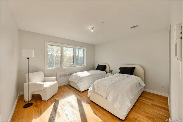 a bedroom with two beds and a large window