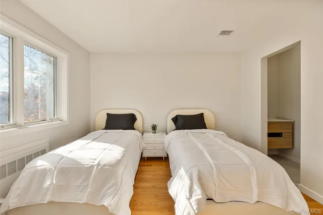 a bedroom with two beds and a large window