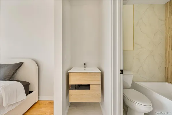 a bathroom with a tub toilet sink and mirror