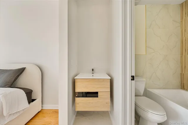 a bathroom with a tub toilet sink and mirror