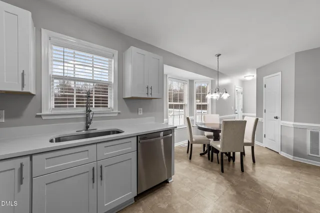 a kitchen with granite countertop white cabinets and stainless steel appliances
