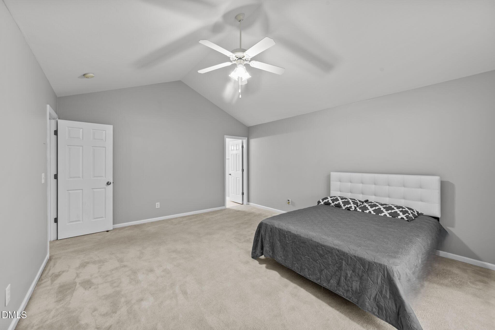 1275 Smith Road Smithfield, NC 27577 - Photo 17 of 41 a bedroom with a large bed and a chandelier
