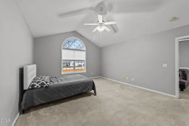 a bedroom with a large bed and a chandelier