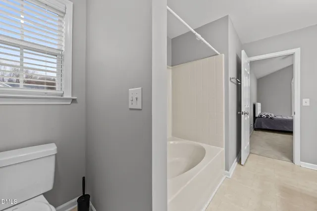 a bathroom with a tub a sink and mirror
