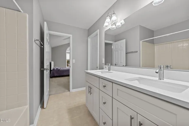 a white bath tub sitting next to a white sink and vanity