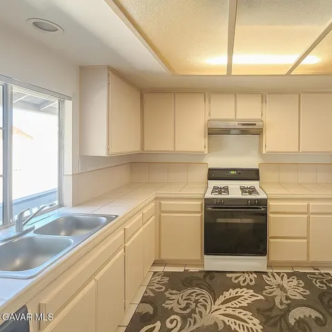 a kitchen with a stove top oven sink and cabinets