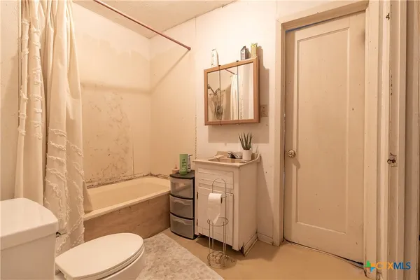 a bathroom with a granite countertop toilet sink and tub