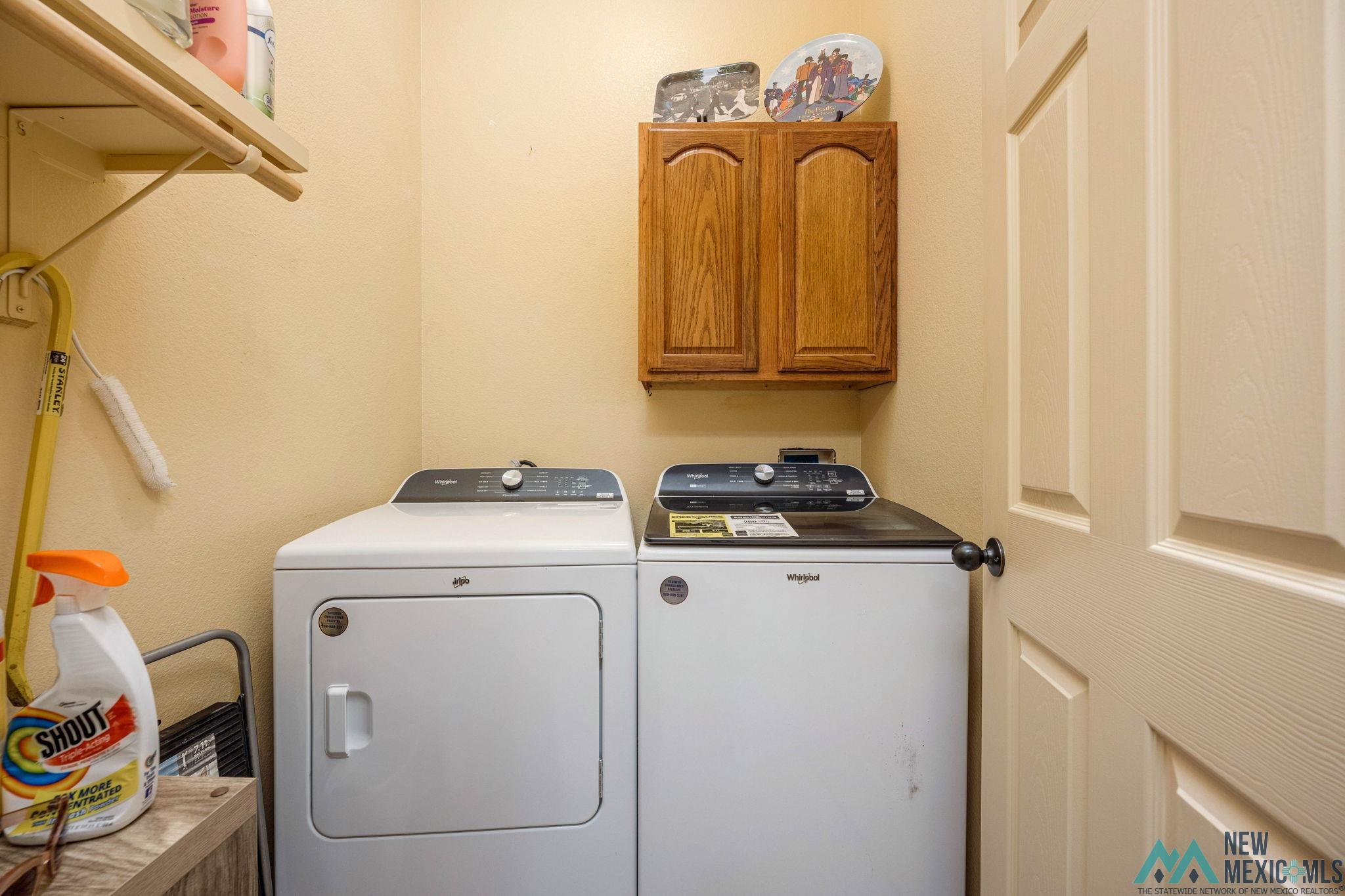 3884 Adriatic Road Las Cruces, NM 88012 - Photo 21 of 45 Dedicated laundry area featuring overhead wood cabinetry and an integrated hanging rod