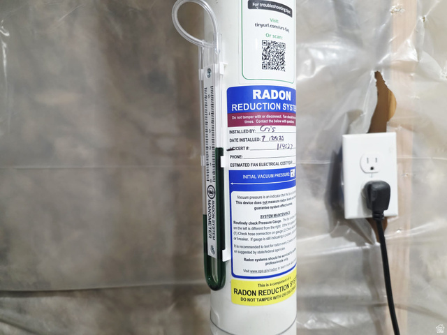 1437 925 South Vernal, UT 84078 - Photo 33 of 47 Radon reduction system featuring a manometer for pressure monitoring, clearly labeled installation details, and an accessible electrical outlet