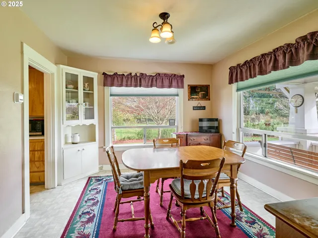 a dining room with furniture a rug and a floor to ceiling window