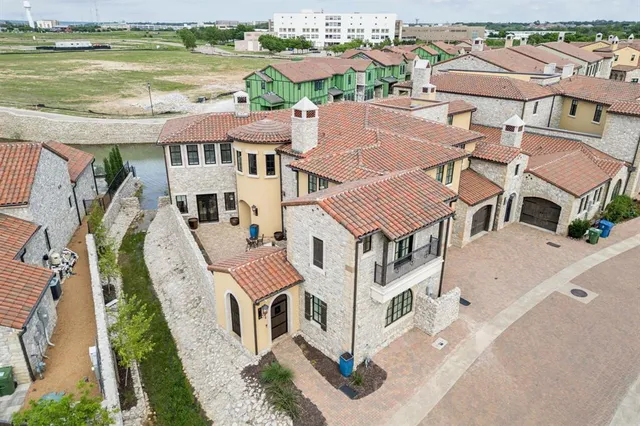 an aerial view of residential houses with outdoor space and ocean view