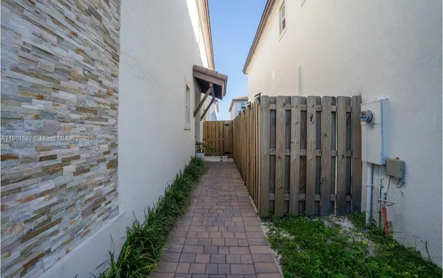 a view of a pathway of a house with wooden fence