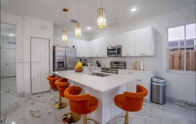 a kitchen with stainless steel appliances granite countertop a sink and a refrigerator