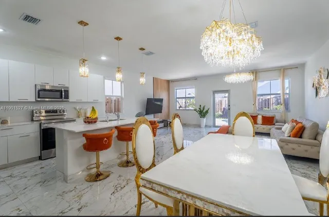 a large white kitchen with a table and chairs