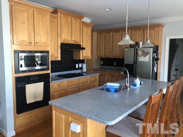 278 Waterville Street Raleigh, NC 27603 - Photo 2 of 7 a kitchen with stainless steel appliances wooden floor dining table and chairs
