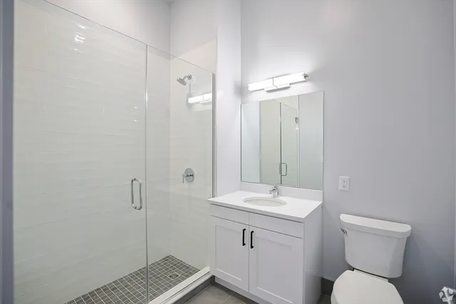 a bathroom with a granite countertop sink toilet and shower